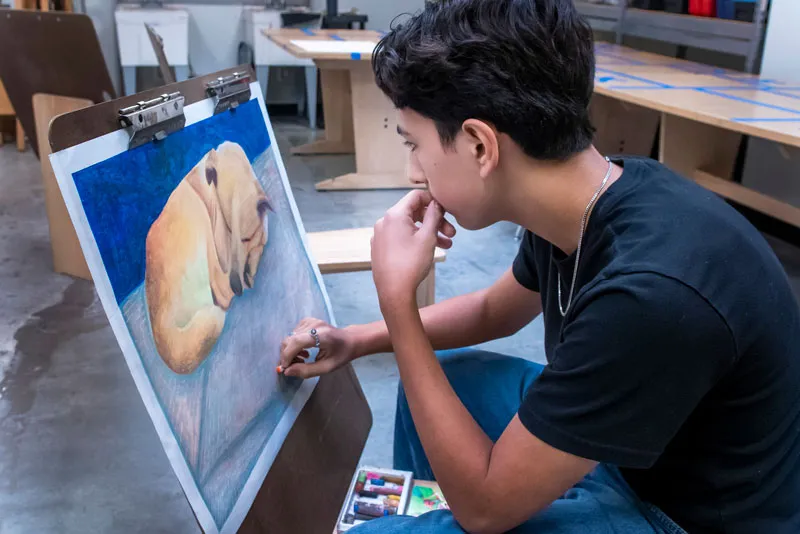 Student painting a dog in class