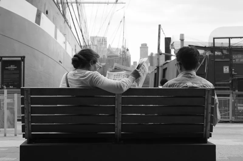 Student class work - black and white image of 2 people sitting on the bench 